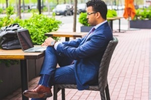 man sitting outside on laptop evaluating influencer marketing platforms