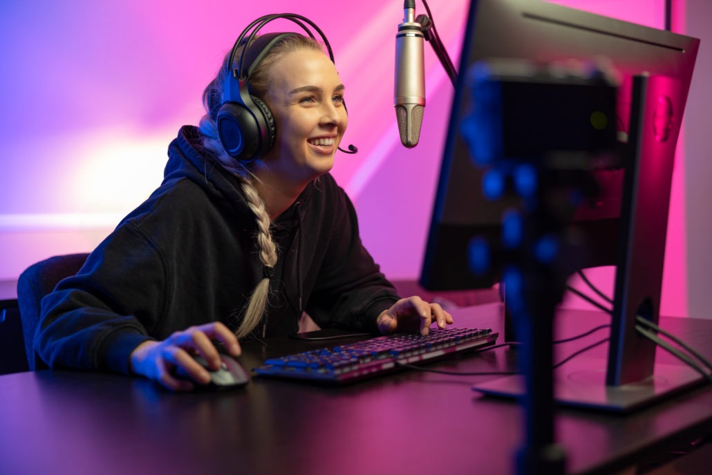 Smiling girl streaming while playing a game.